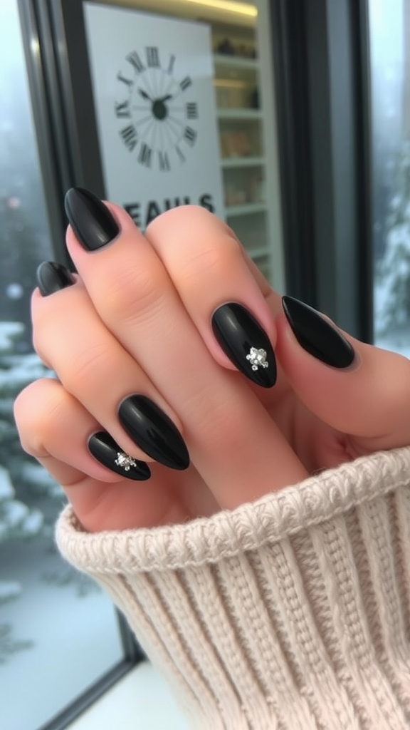 Close-up of stylish black nails with metallic accents against a cozy sweater background.