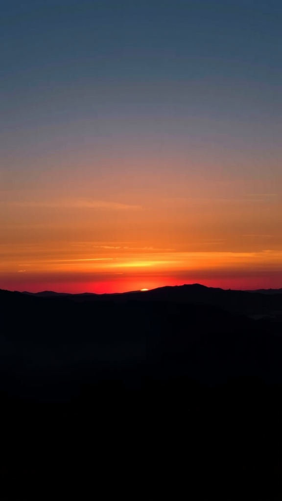 A silhouette of mountains against a colorful sunset sky