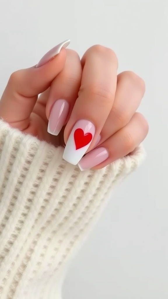 Close up of nails featuring a chic nude color with a red heart accent on a short nail design.