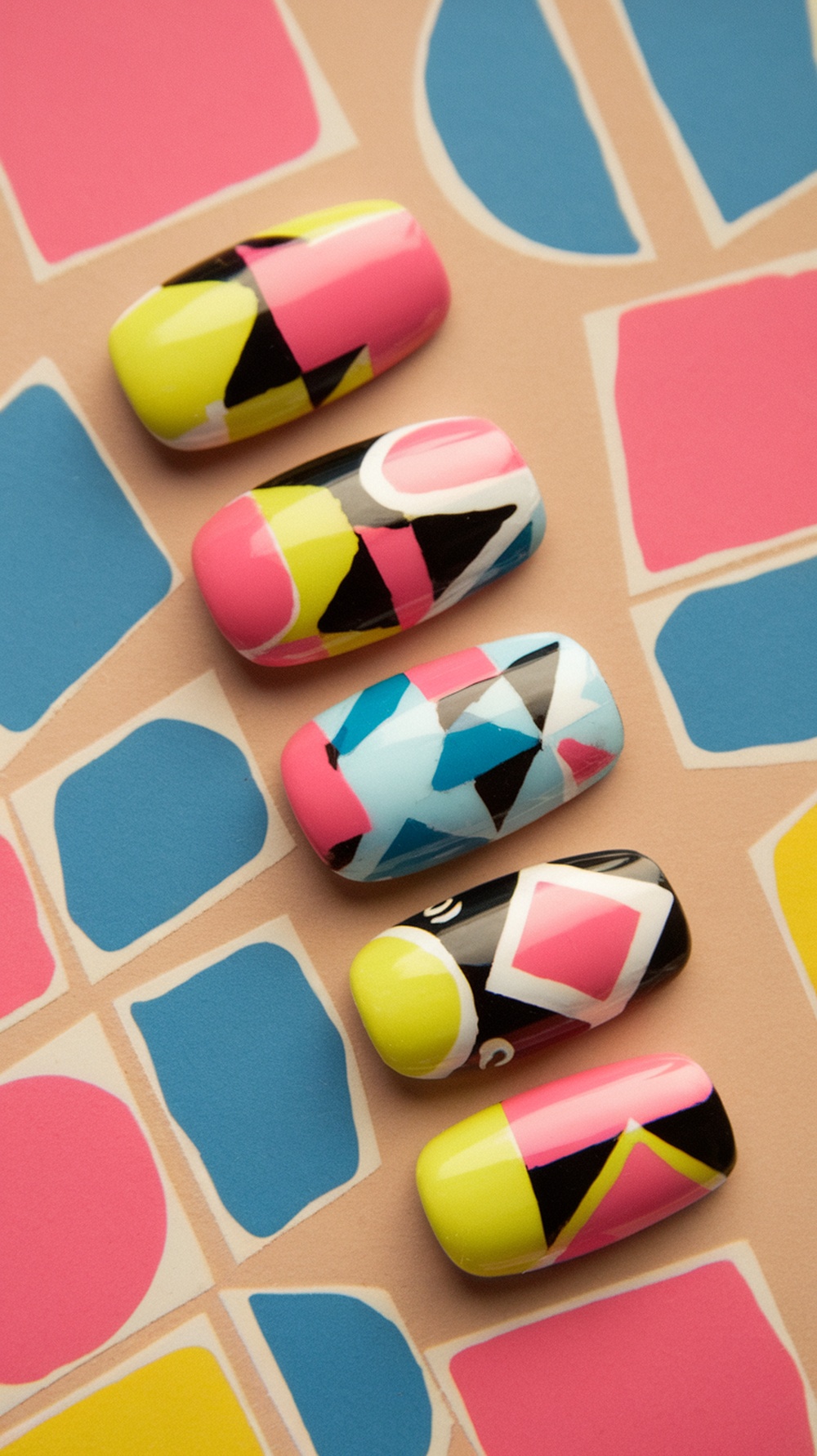 Colorful summer nails with geometric patterns on a pastel background