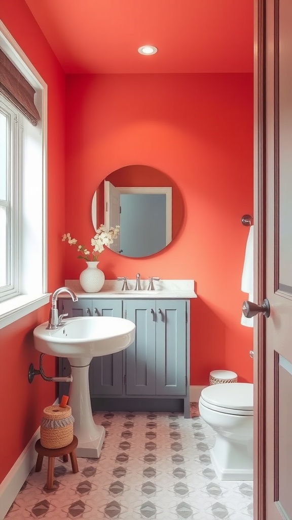 A bright coral bathroom with soft gray cabinetry and a circular mirror.