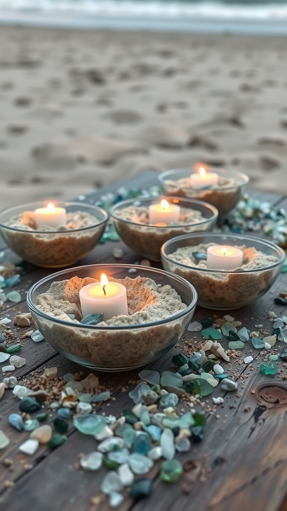 Shallow bowls filled with sand and candles surrounded by colorful sea glass on a wooden surface by the beach.