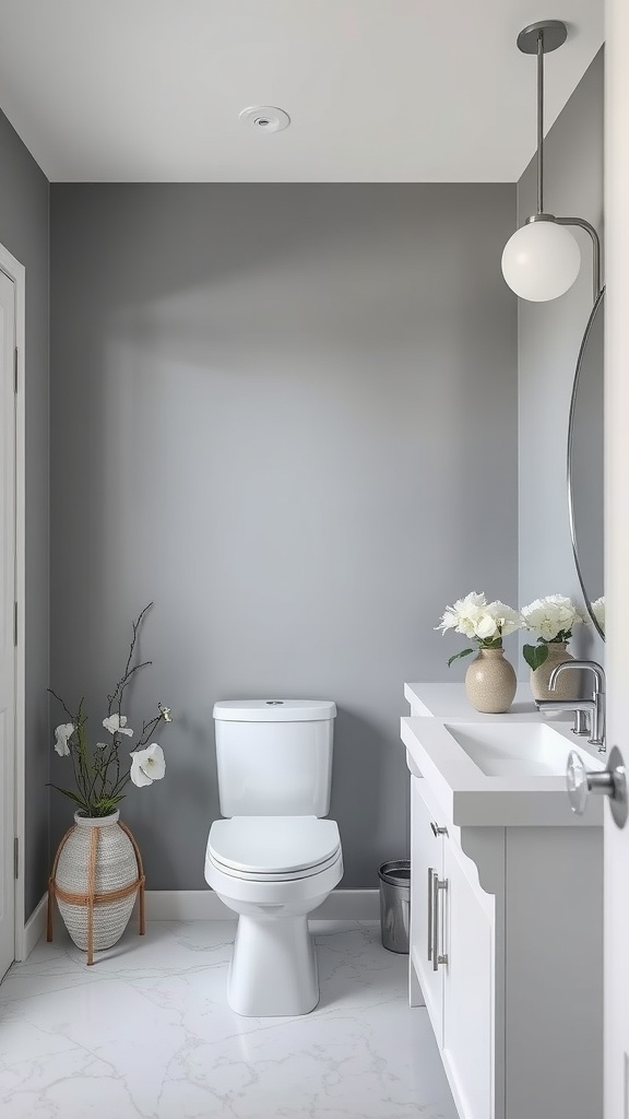 A bathroom featuring a gray accent wall with white decor, including a modern toilet and sink, and decorative flowers.