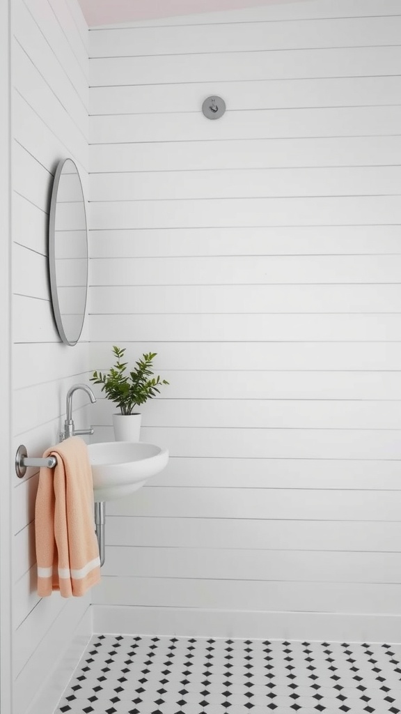 A bright farmhouse bathroom featuring shiplap wall panels, a sleek sink, round mirror, and a pop of color from a peach towel.