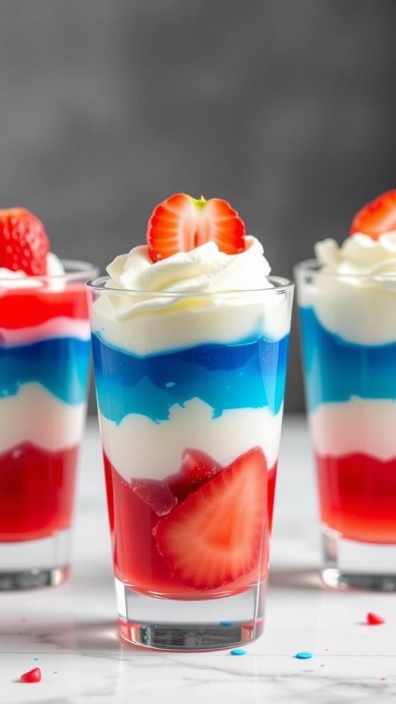 Colorful layers of red, white, and blue Jello cups topped with whipped cream and strawberries