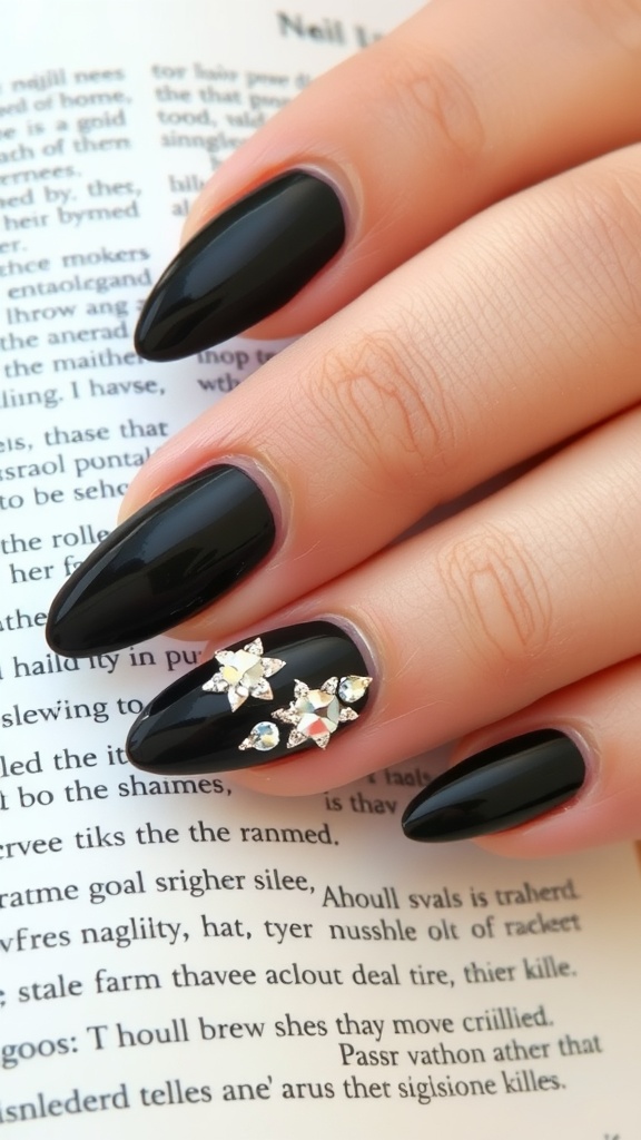 Classic black nails with rhinestones on a hand resting on an open book.