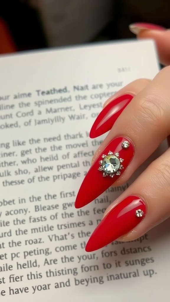 A hand with long red nails featuring decorative gems, resting on an open book.