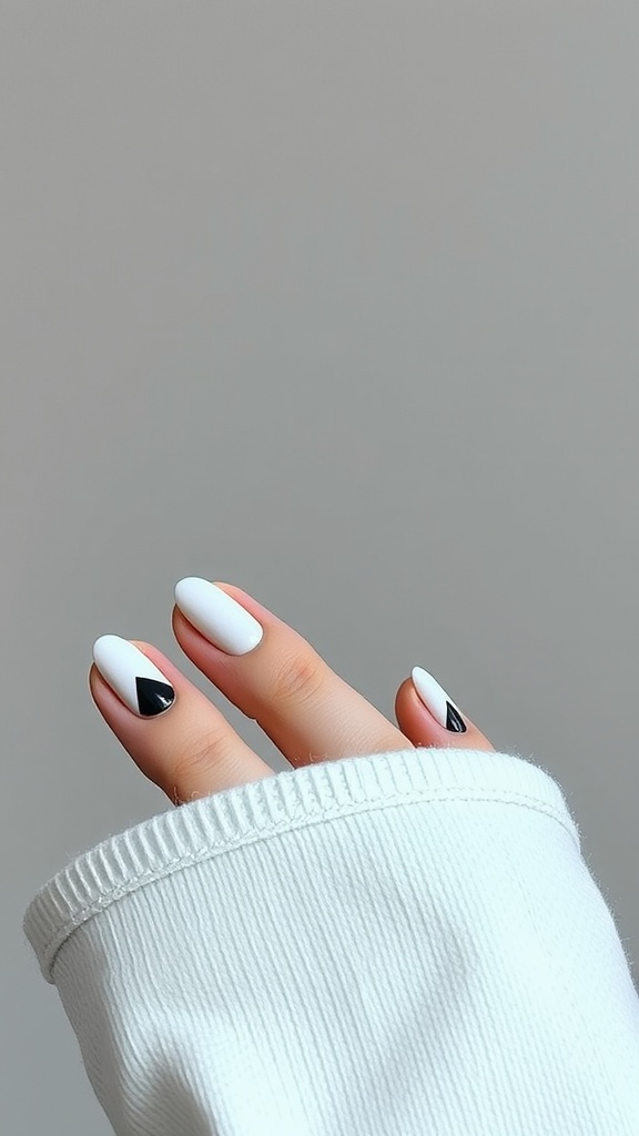 Nails featuring geometric designs in black and white colors.