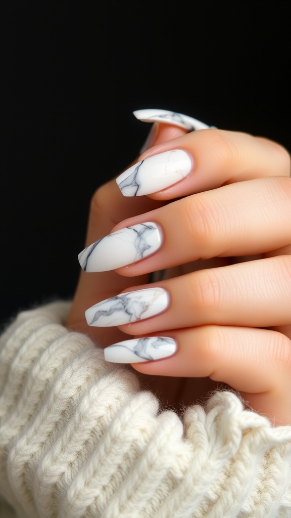 A close-up of hands with marble effect nails, featuring white and grey swirls.