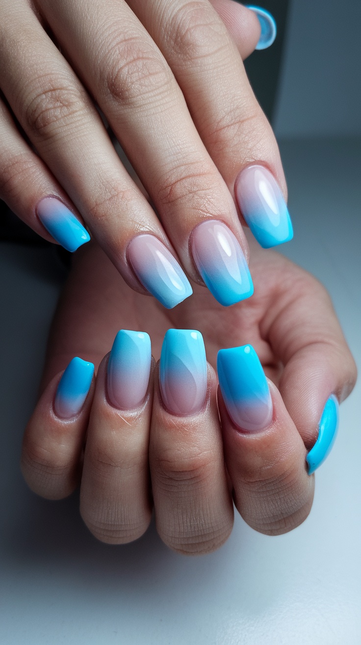 Acrylic nails featuring a gradient design in blue tones, resembling a winter sky.