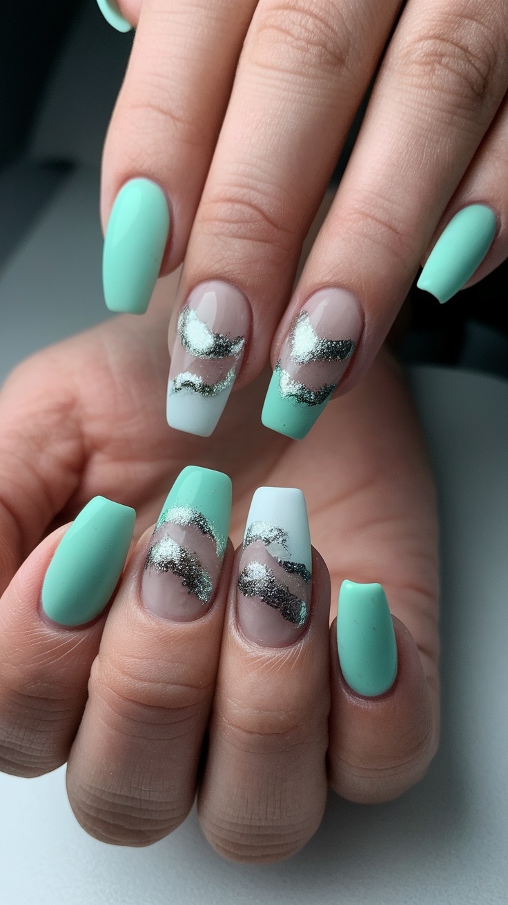 Acrylic nails featuring seafoam green color with silver wave-like accents.