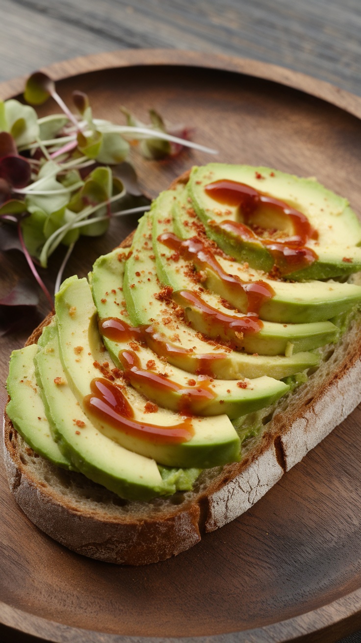 A slice of avocado toast topped with hot sauce and served on a wooden plate.