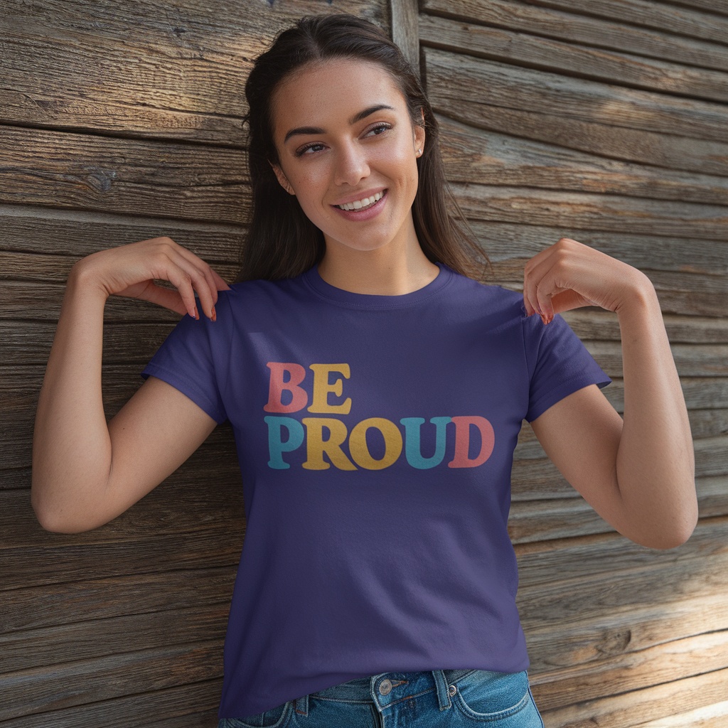 A woman wearing a purple t-shirt that says 'BE PROUD' in colorful letters.
