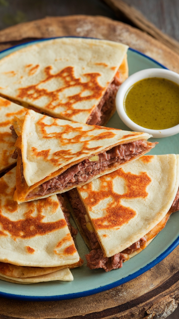 A plate of crispy beef and cheese quesadillas served with salsa verde.