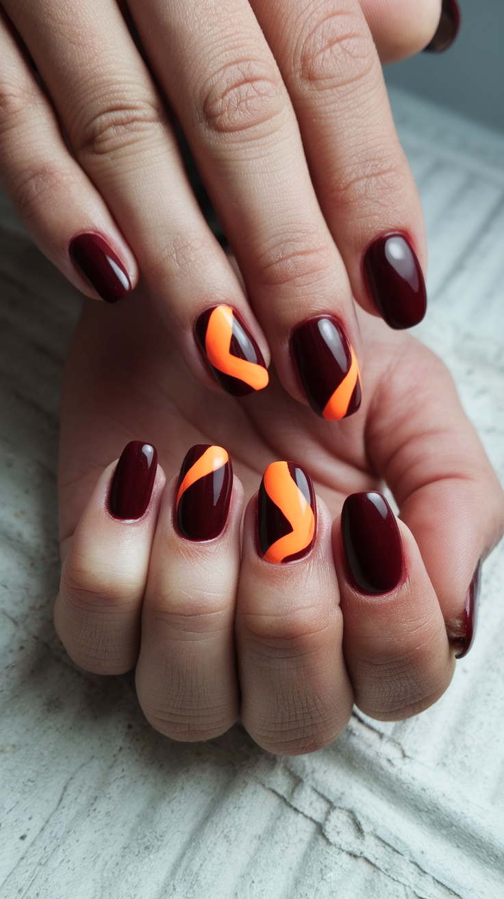 Nail design featuring dark cherry red base with orange swirls