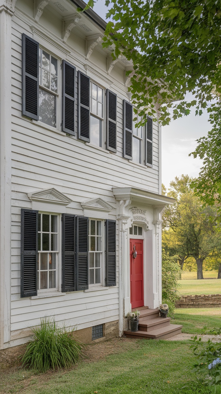 Historic house with white siding, black shutters, and a red door