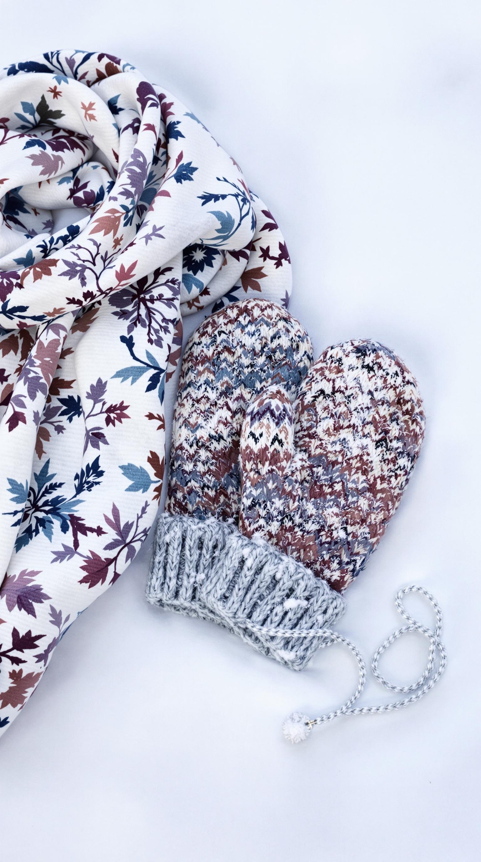 A pair of knitted mittens and a floral scarf ready for winter.