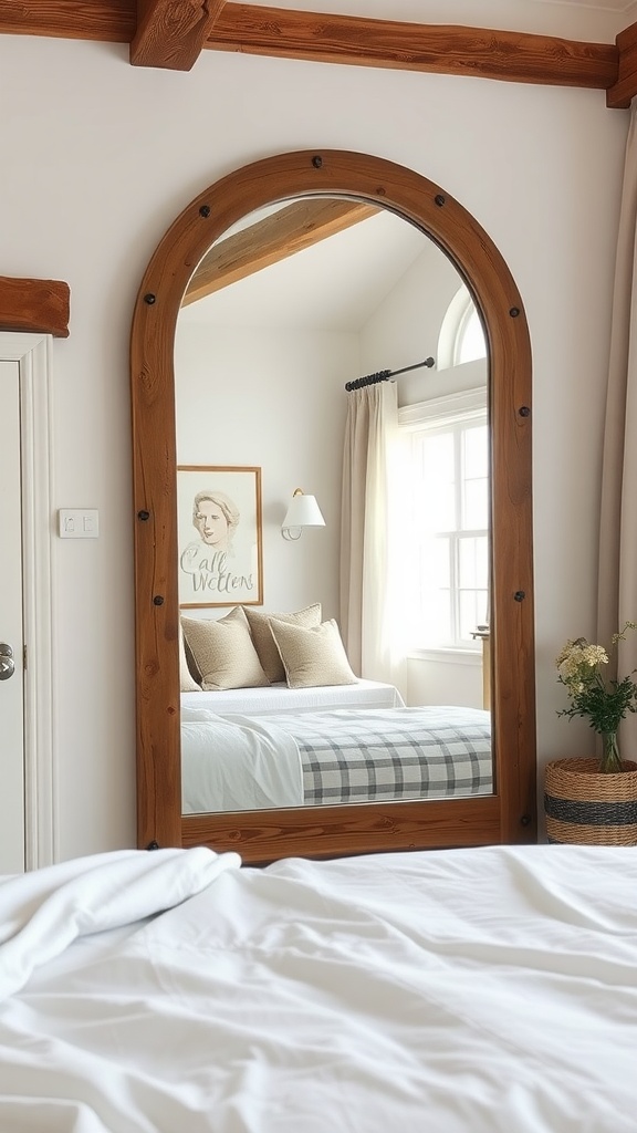 A rustic arched mirror reflecting a cozy farmhouse bedroom with soft bedding and natural light.
