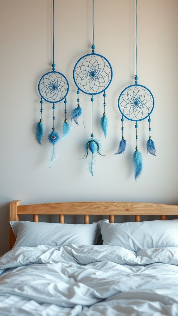 Three blue dream catchers hanging above a cozy bed with light blue bedding.