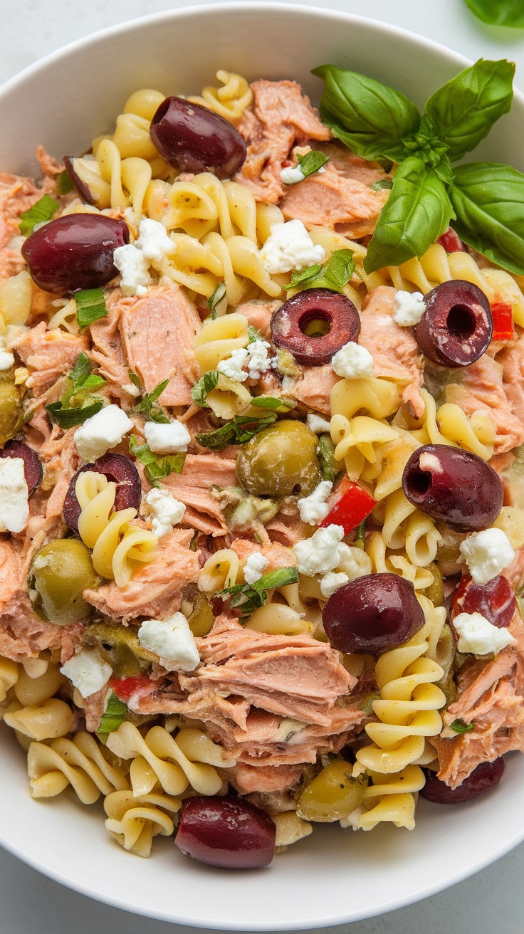 A vibrant bowl of Tuna Pasta Salad featuring noodles, olives, tomatoes, and herbs.