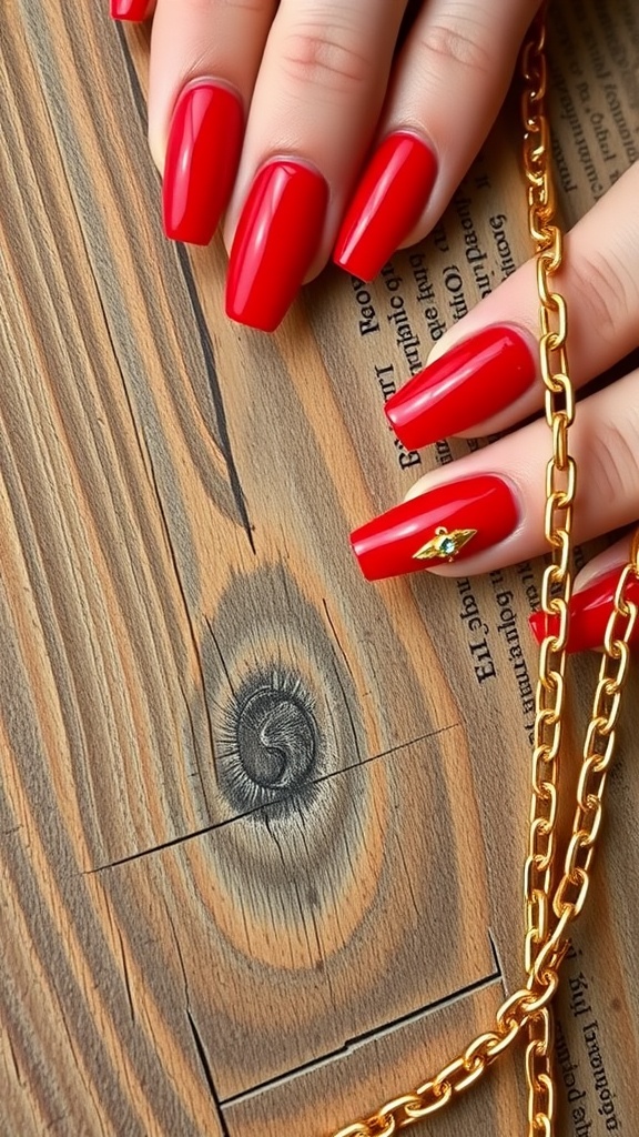 Close-up of bold red nails with gold chain detail on wooden background.
