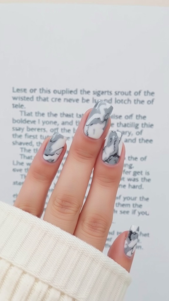 A hand displaying square nails with a chic marble effect design.