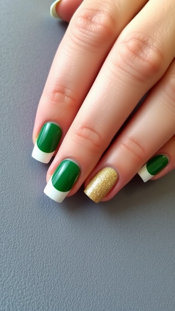 A hand with green and gold nails featuring a classic French manicure style.