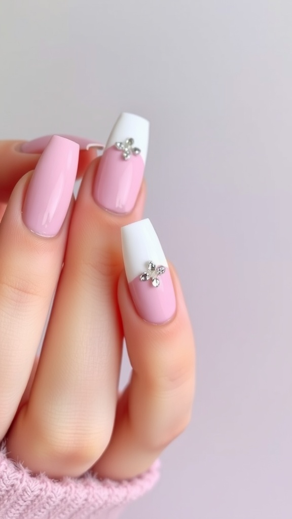 A close-up of pink and white nails with crystal embellishments.