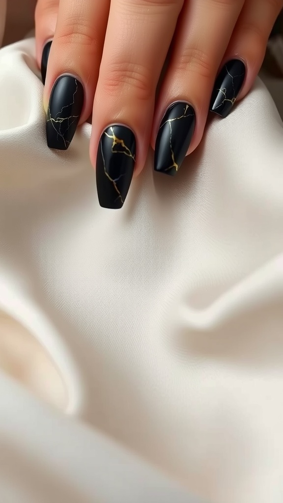 Elegant black nails with a golden marble effect design