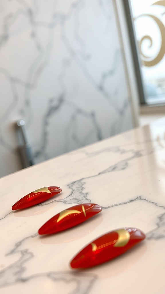 Nails featuring a lustrous red color with gold abstract shapes