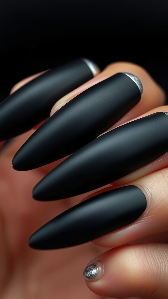 A close-up of black matte coffin nails with glossy tips, showcasing a chic nail design.