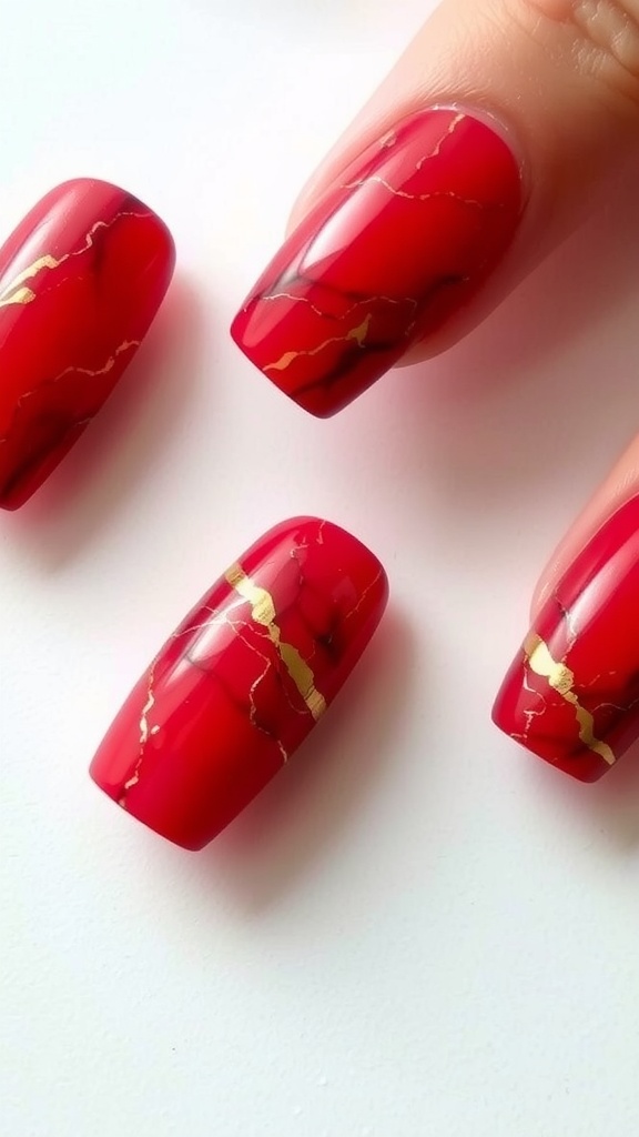 Red marble nail art with gold accents on nails