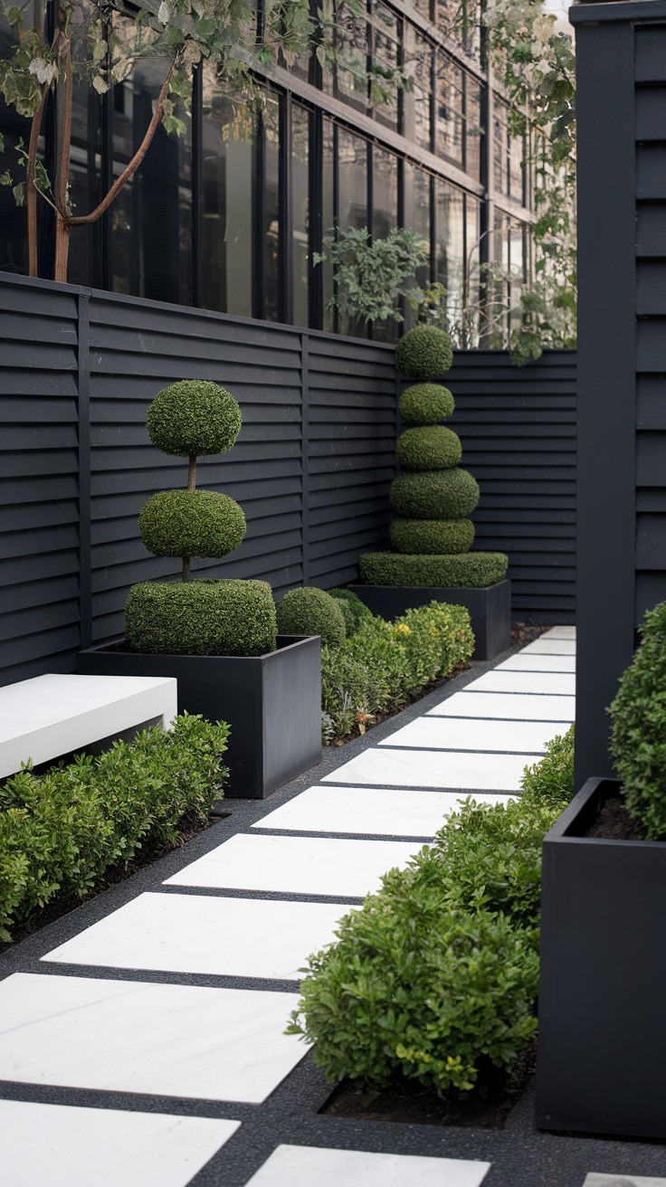 A stylish side yard featuring black fencing, white stepping stones, and neatly trimmed greenery.