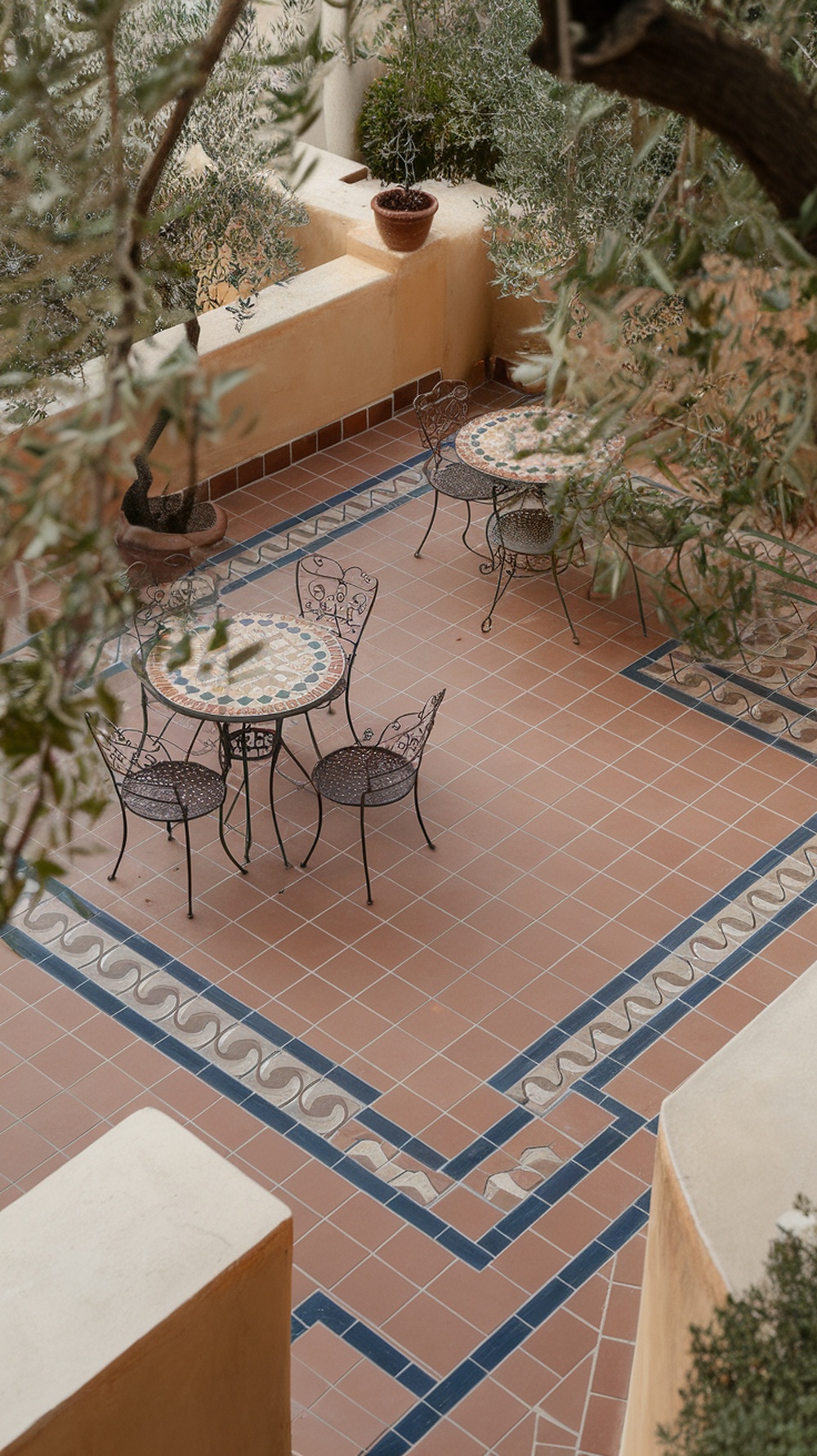 Mediterranean tile terrace with a table and chairs surrounded by greenery