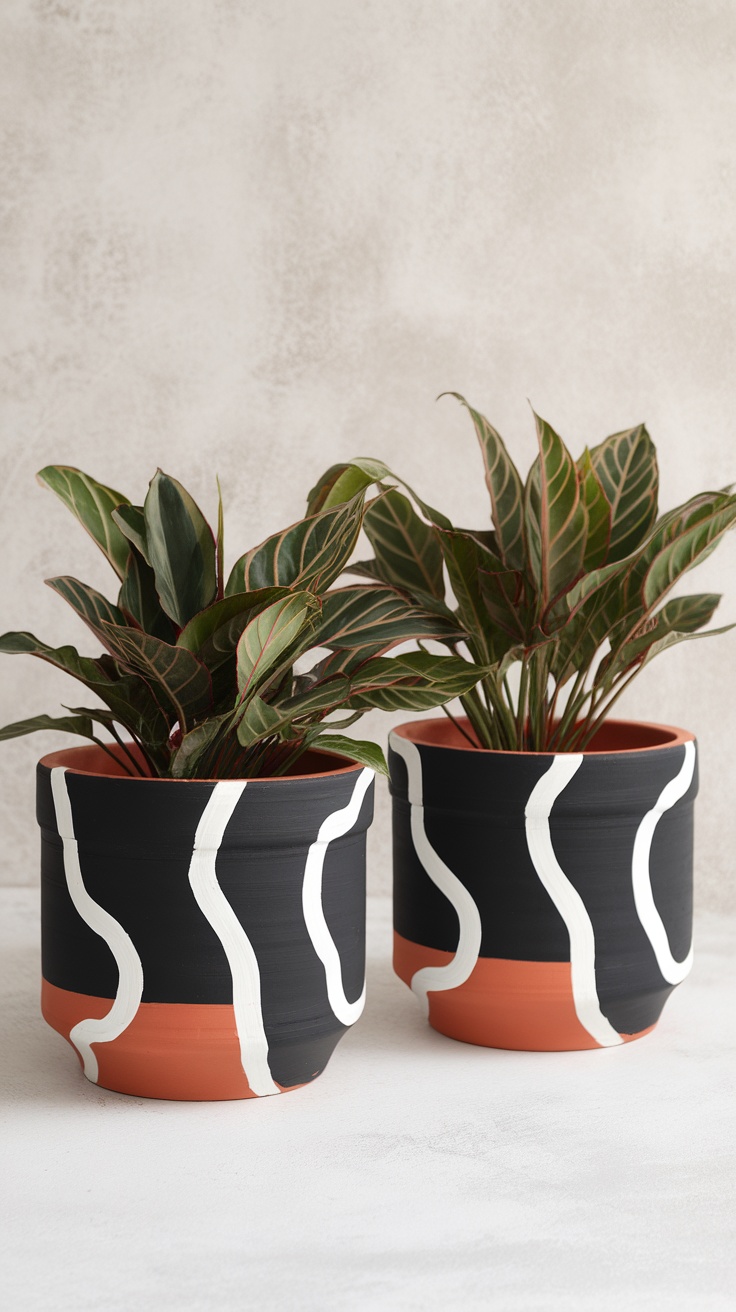 Two modern hand-painted terracotta pots with bold patterns and plants.