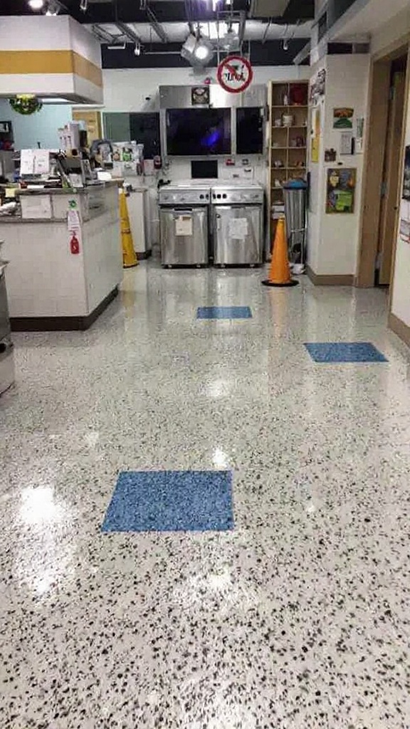 Interior flooring in a commercial kitchen with blue tiles and stainless steel appliances.