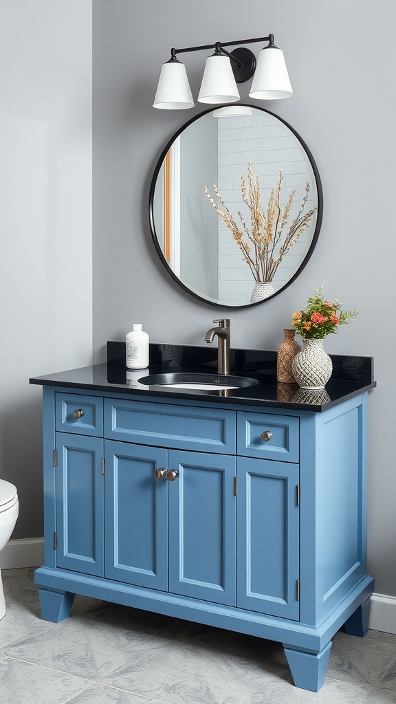 A blue bathroom vanity with a black countertop and a round mirror above it.