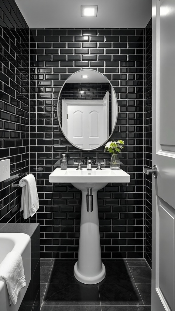 A black tile bathroom featuring glossy black walls, a white pedestal sink, and an oval mirror.