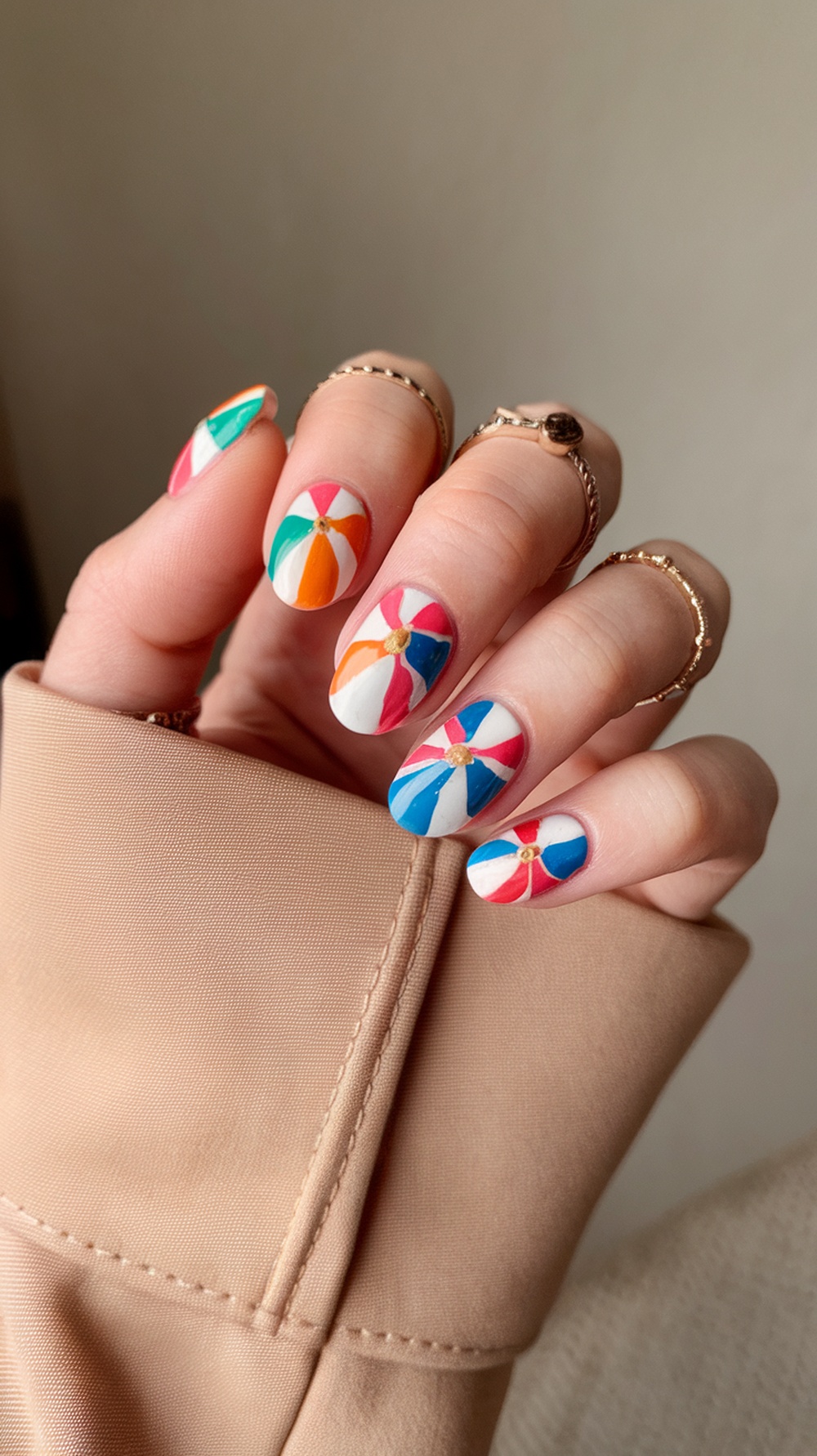 Colorful beach ball design on nails with various patterns and colors.