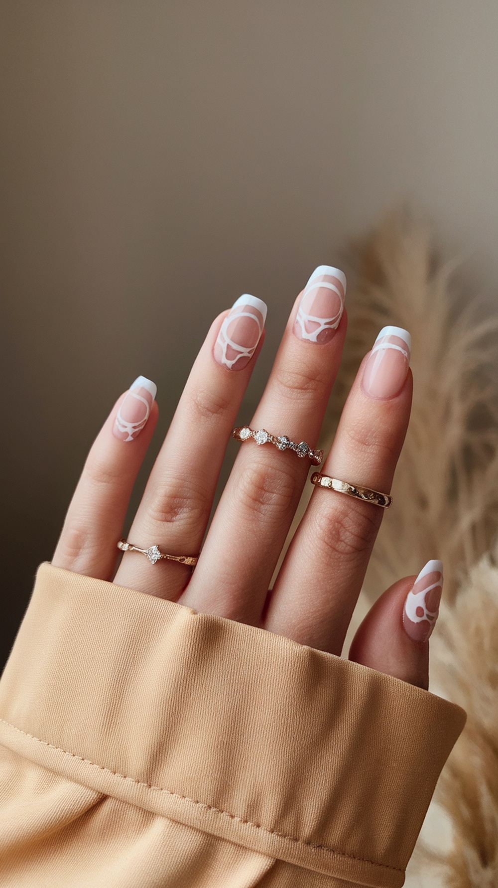 Short nails with negative space design featuring white accents and elegant rings.