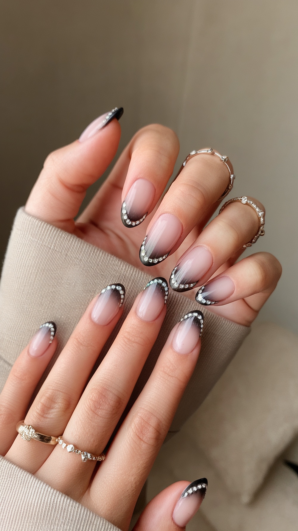 Chic ombre nails with rhinestone finish, featuring a gradient from nude to black tips.