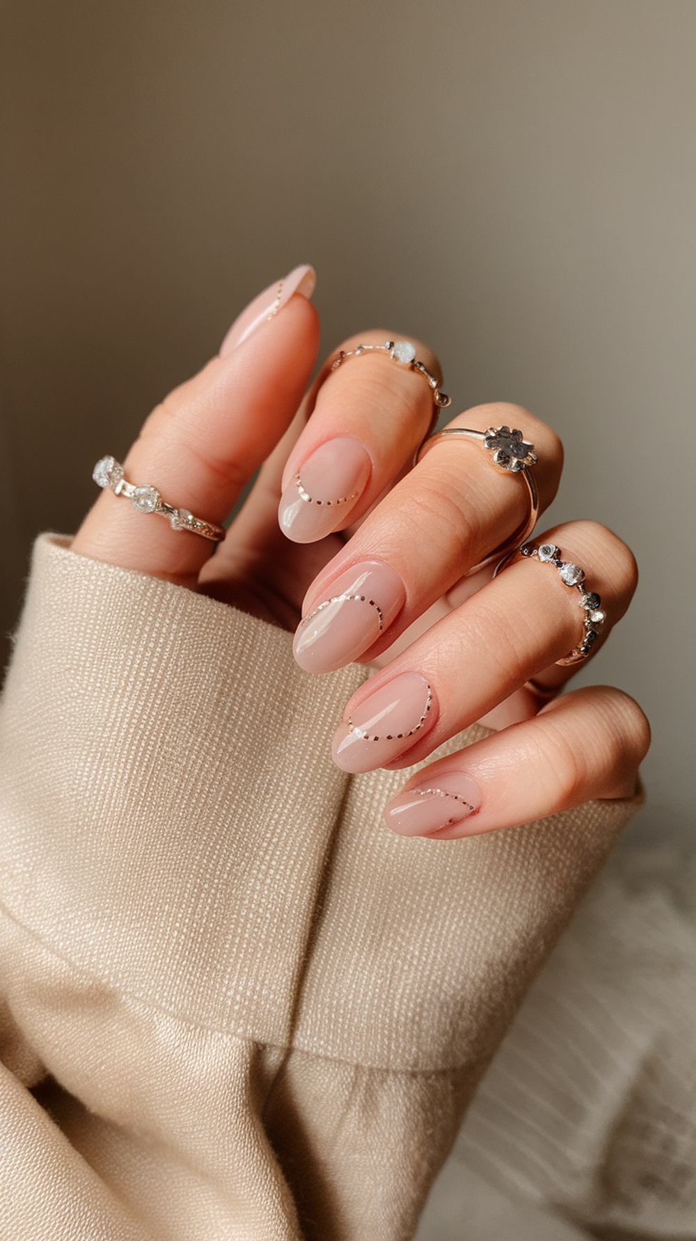 Nude base nails with classic French tips and delicate rings