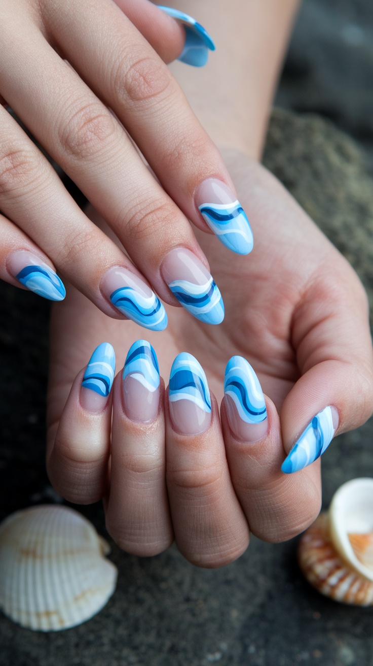 Close-up of hands with coastal wave nail designs, featuring shades of blue and white patterns.