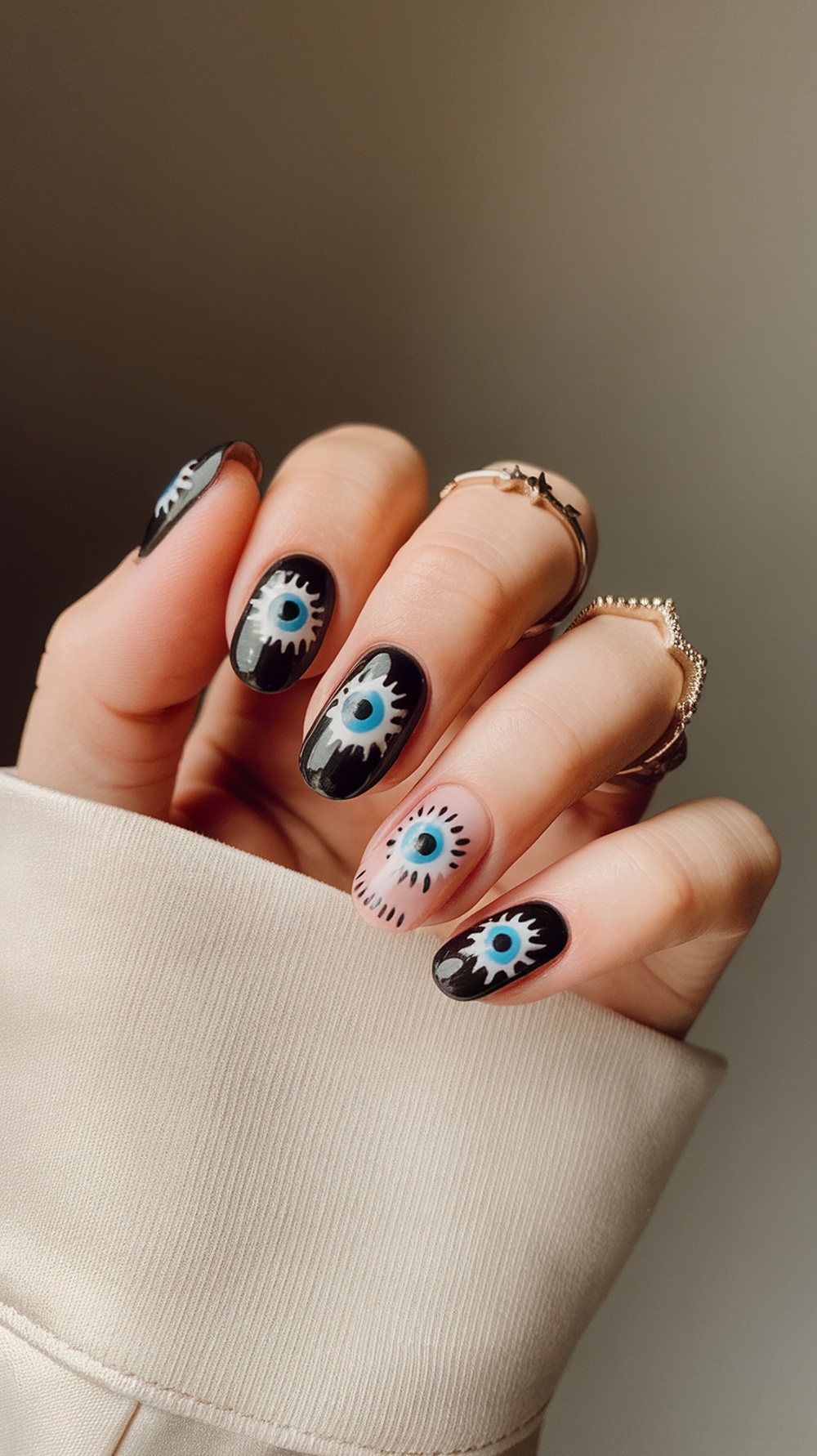 Close-up of spooky nail designs featuring eerie eye motifs in black and blue.