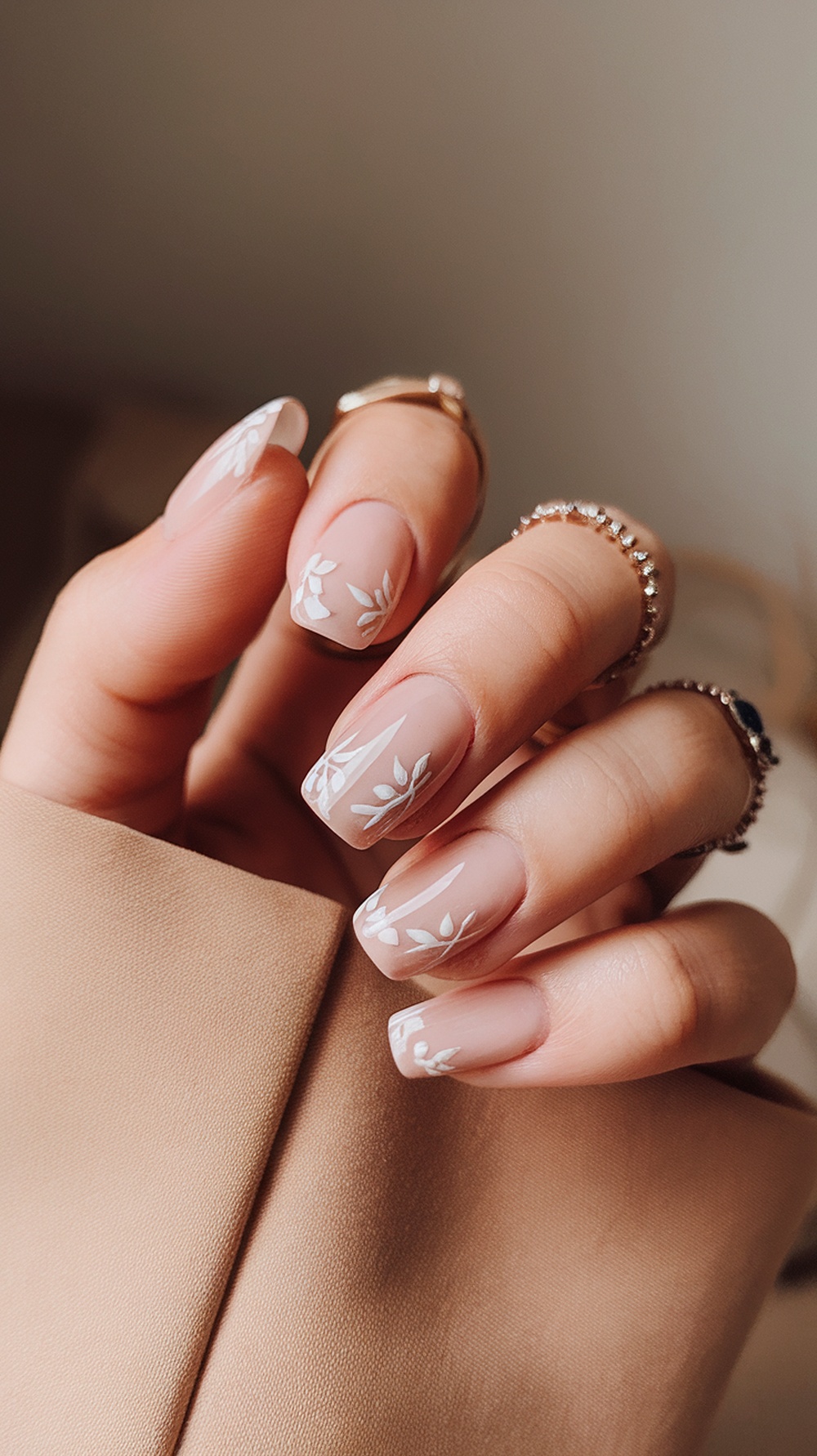 Short nails with floral accents on a neutral base