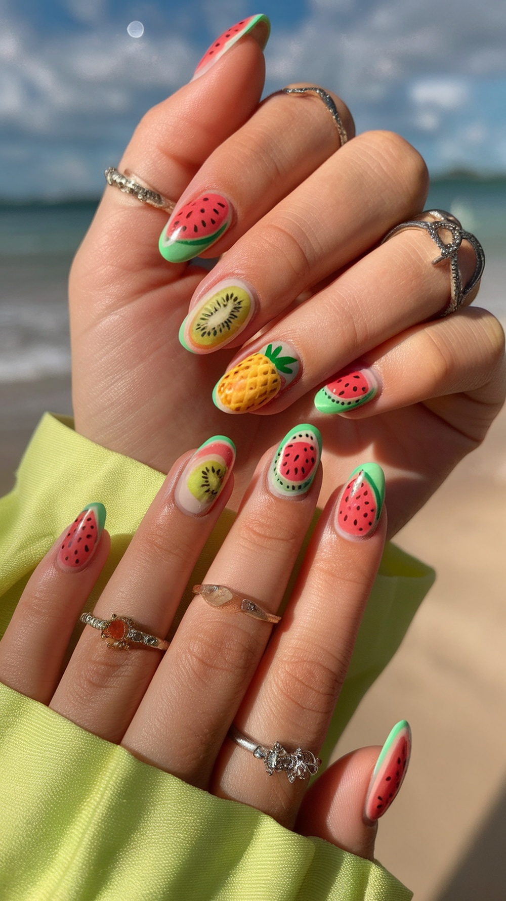 Colorful fruit-inspired nail designs featuring watermelon, kiwi, and pineapple.