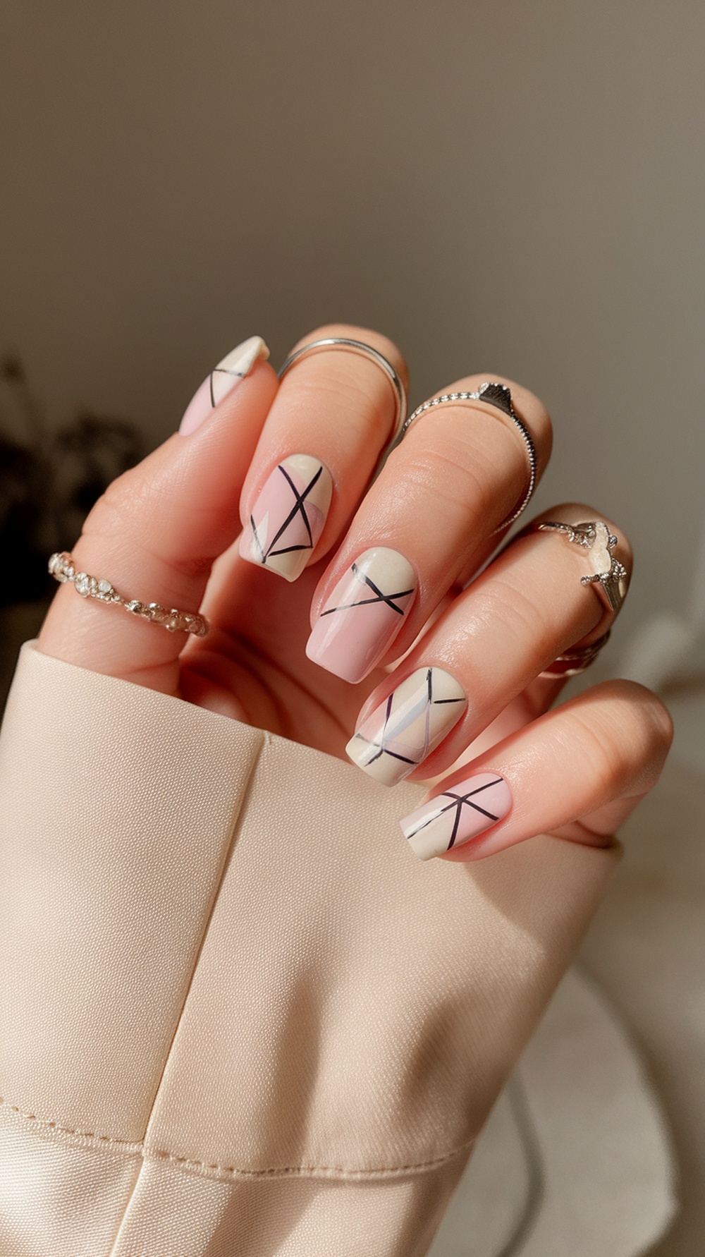Close-up of short nails with minimalist geometric patterns in pastel colors