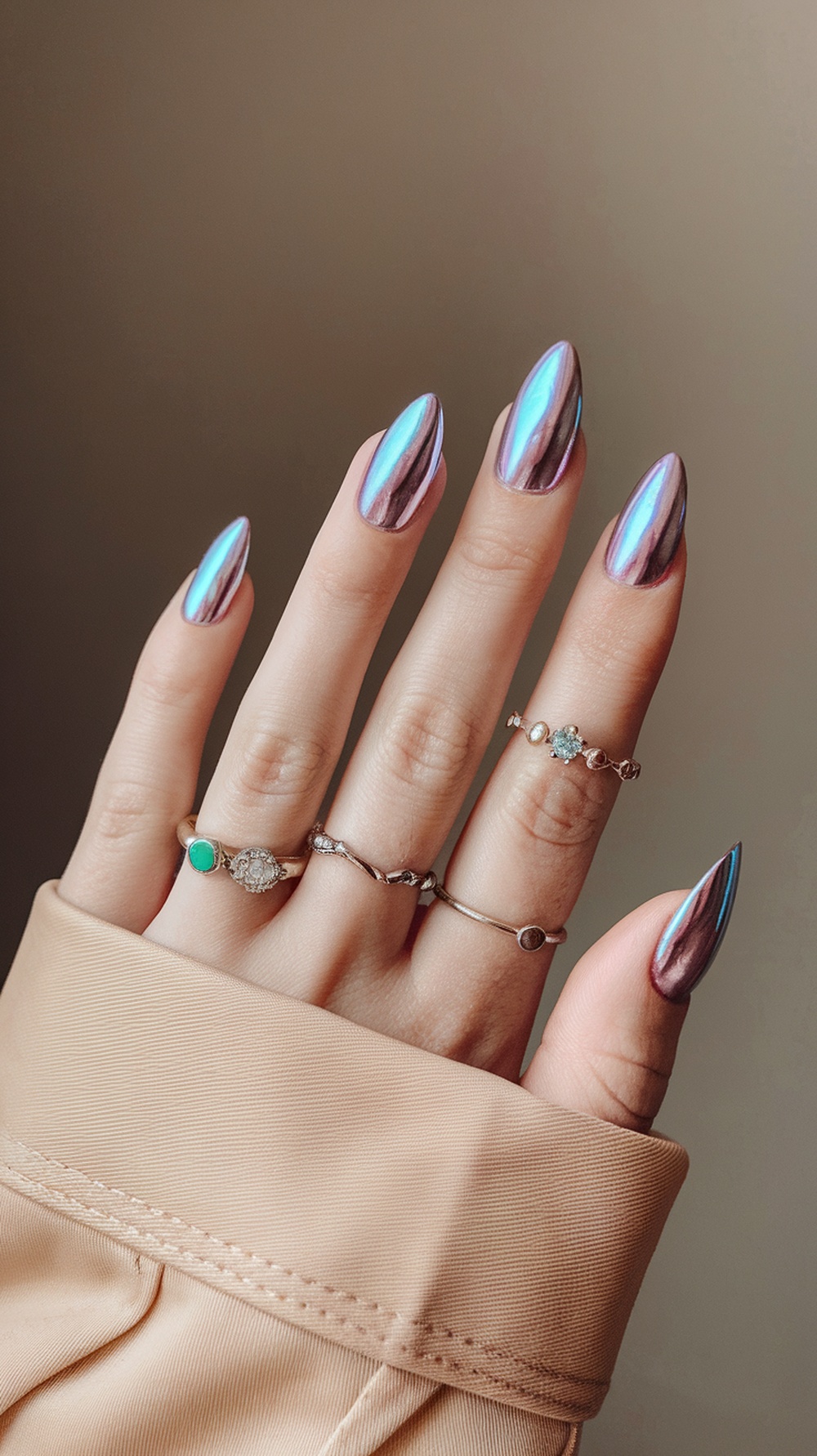 Close-up image of hands with cotton candy chrome nails in a pointed shape.
