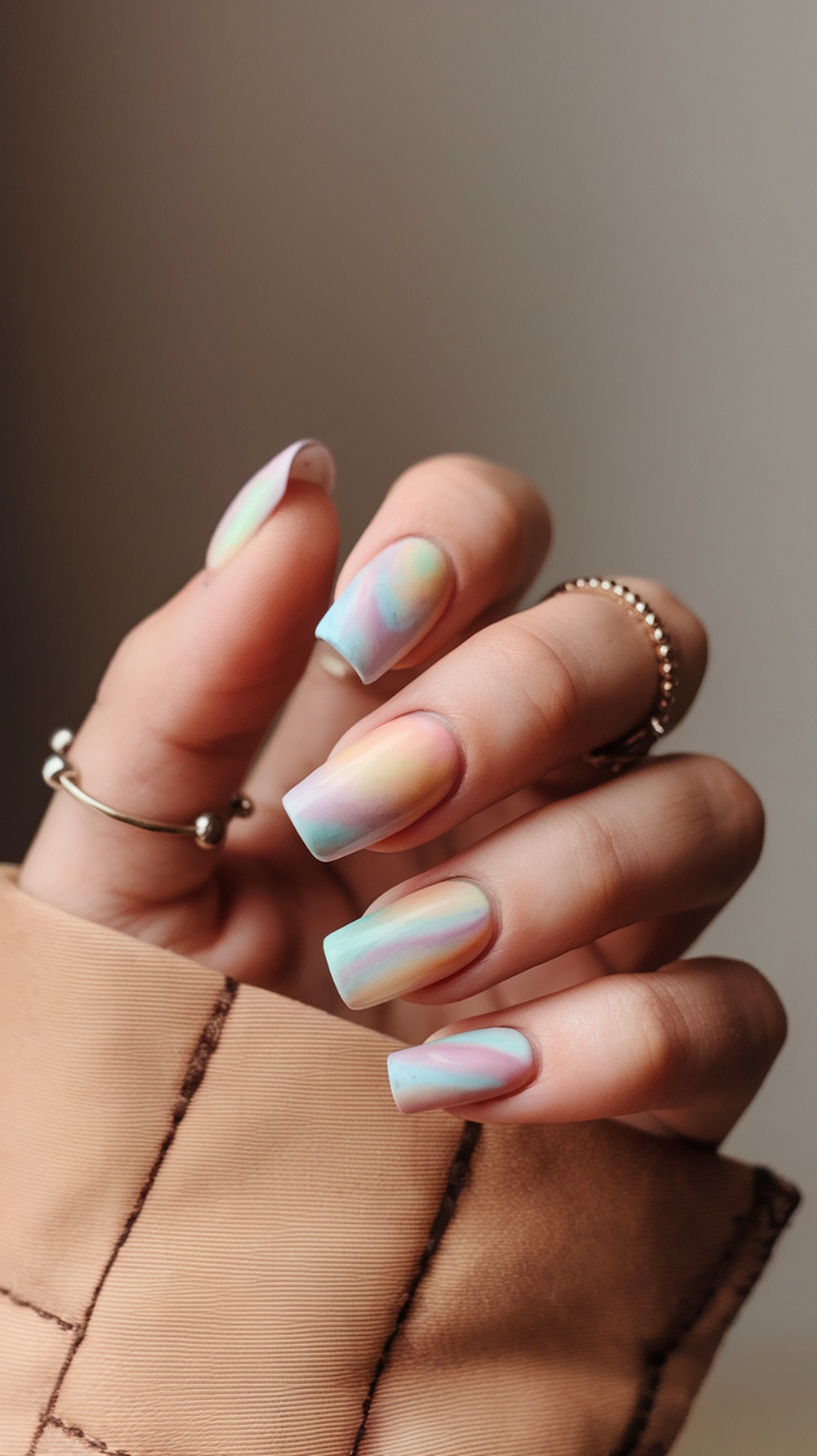 Nails with a pastel tie-dye effect in soft colors.