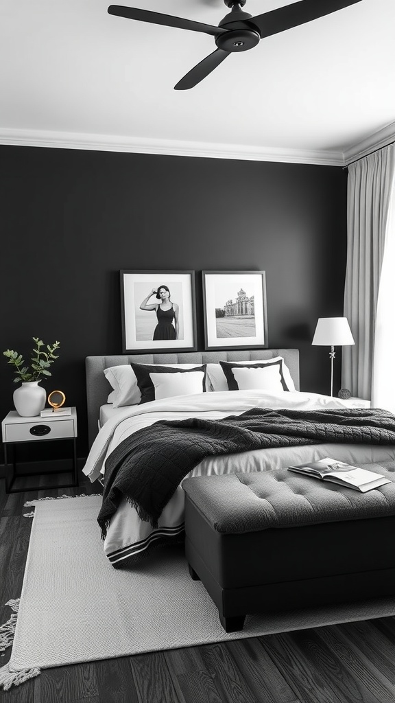 A monochrome bedroom featuring a black wall, layered gray and white bedding, framed black and white artwork, and a bedside table with a plant.